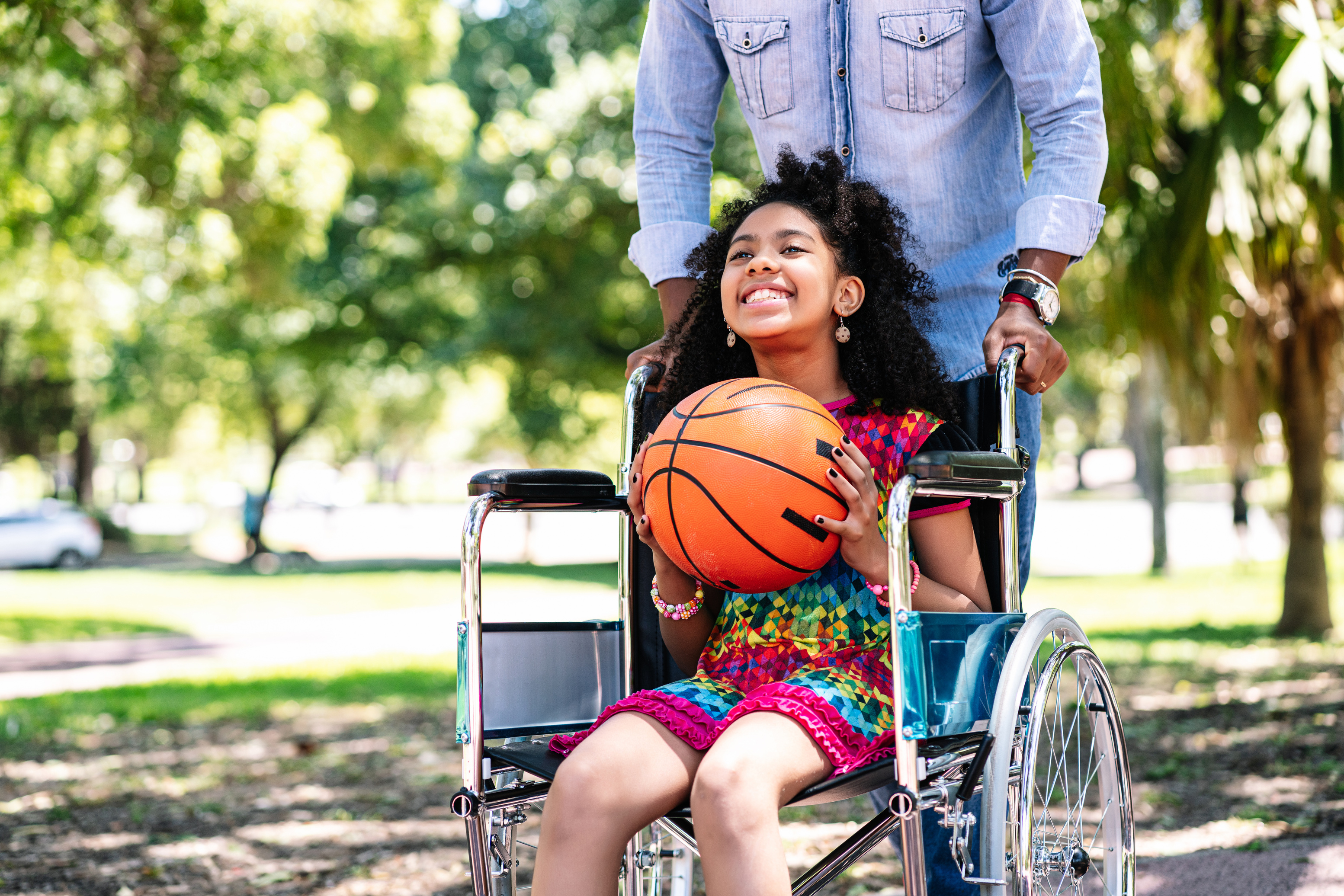 Little Girl in a Wheelchair Playing Basketball with Her Father.